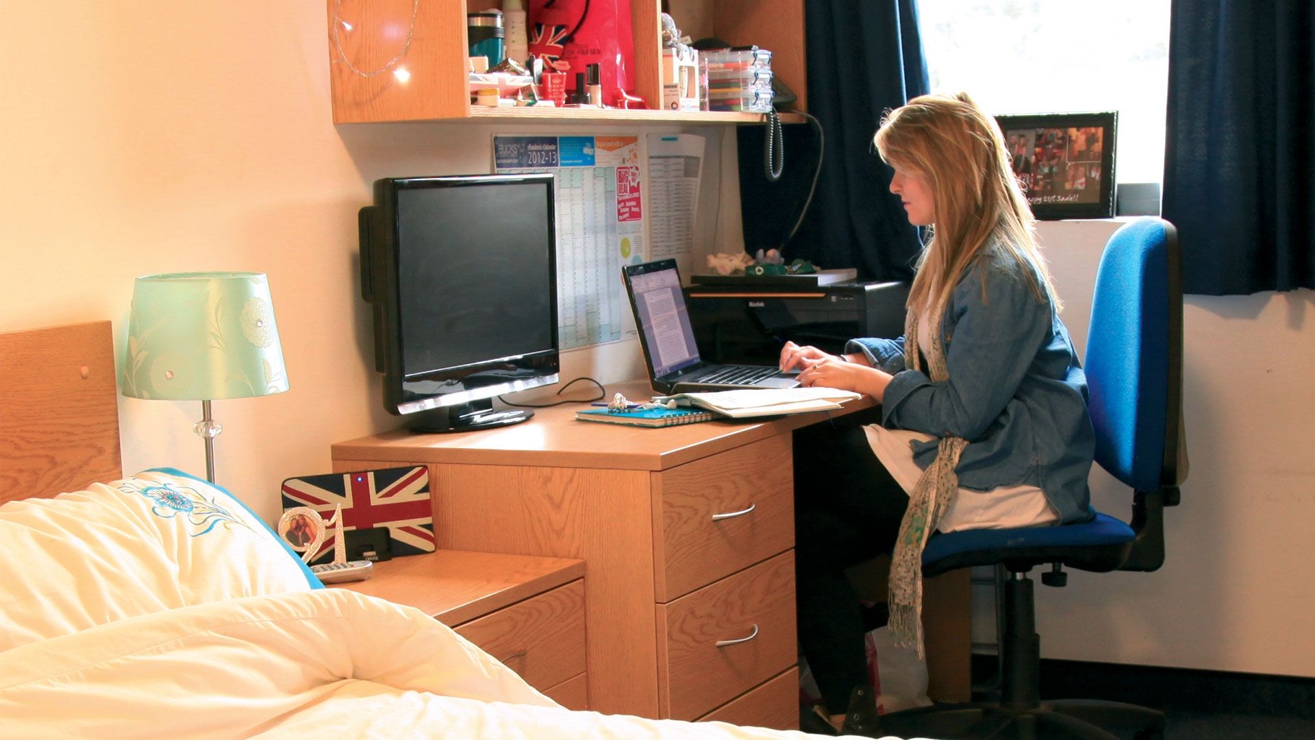 Bucks student sitting at her desk in bedroom student accommodation